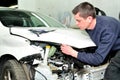 Mechanic inspecting car body damage at auto repair shop service Royalty Free Stock Photo