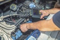 Mechanic inspecting car engine with video borescope Royalty Free Stock Photo