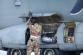 A mechanic is inspecting parts of an Alenia C-27J Spartan military cargo plane after landing on an airbase Royalty Free Stock Photo