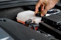 Mechanic inspects the expansion tank with pink antifreeze. Vehicle coolant level in the car`s radiator system. auto parts