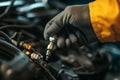 A mechanic is installing a spark plug in a vehicle engine for maintenance Royalty Free Stock Photo