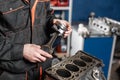 The mechanic installs a new piston. Disassemble engine block vehicle. Motor capital repair. Sixteen valves and four Royalty Free Stock Photo