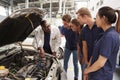 Mechanic instructing trainees around the engine of a car Royalty Free Stock Photo