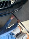 Mechanic Laying on Floor to jack up Car