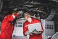 Mechanic male team staff worker working together under car auto service check tuning in garage Royalty Free Stock Photo