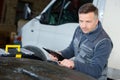 Mechanic man holding clipboard and check car Royalty Free Stock Photo