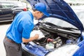 Mechanic man holding clipboard and check the car Royalty Free Stock Photo