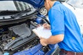 Mechanic man holding clipboard and check the car Royalty Free Stock Photo