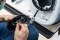 Mechanic man installing speaker on vehicle door part in garage Royalty Free Stock Photo