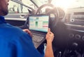 Mechanic man with laptop making car diagnostic Royalty Free Stock Photo