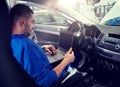 Mechanic man with laptop making car diagnostic Royalty Free Stock Photo