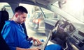 Mechanic man with laptop making car diagnostic Royalty Free Stock Photo