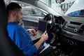 Mechanic man with laptop making car diagnostic Royalty Free Stock Photo