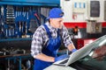 Mechanic man with laptop making car diagnostics at service Royalty Free Stock Photo