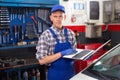 Mechanic man with laptop making car diagnostics at service Royalty Free Stock Photo