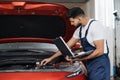 Mechanic man mechanic manager worker using a laptop computer checking car Royalty Free Stock Photo