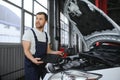 Mechanic man mechanic manager worker using a laptop computer checking car in workshop at auto car repair service center Royalty Free Stock Photo