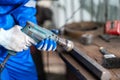 Mechanic man repairing brake disc of car using lathe tool polishing at garage. Engineer using metal polishing machine to make flat