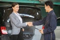 Mechanic man shaking hands with customer at the repair garage. Auto mechanic shaking hands with young woman client, Car repair and Royalty Free Stock Photo