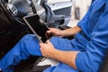 Mechanic man with tablet pc making car diagnostic Royalty Free Stock Photo