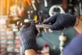 Mechanic man using a Vernier caliper to measure Piston rod or engine part at motorcycle shop , selective focus Royalty Free Stock Photo