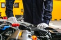 Mechanic man working on the engine of the car in the garage.Car service and maintenance,Repair service.Checks car engine under the