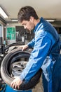 Mechanic Mounting Car Tire On Alloy Rim In Garage Royalty Free Stock Photo