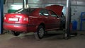 Mechanic is moving gas tank on trolley to do welding the bottom of the car.