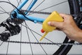 Mechanic oiling bicycle chain and gear with oil