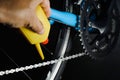 Mechanic oiling bicycle chain and gear with oil