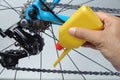 Mechanic oiling bicycle chain and gear with oil