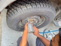 A mechanic opening the nuts and bolts with the help of an electric tool to replace a tyre