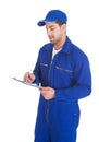 Mechanic In Overall Writing On Clipboard Royalty Free Stock Photo