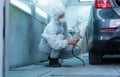 Mechanic painting car in chamber. Worker using spray gun and airbrush and painting a car, Garage painting car service repair and