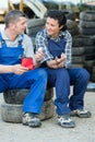 mechanic passing bandage to young female colleague with injured arm