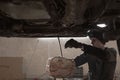 A mechanic performing diagnostics and repairs of a car, the front and background background is blurred with bokeh effect