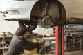 A mechanic performing diagnostics and repairs of a car, the front and background background is blurred with bokeh effect