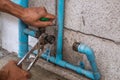 A Mechanic Plumber is Repairing a Leaking Water Pipe Tap Near the Water Meter