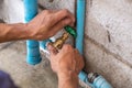 A Mechanic Plumber is Repairing a Leaking Water Pipe Tap Near the Water Meter