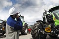 Mechanic pointing at large farming tractors Royalty Free Stock Photo