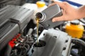 Mechanic pouring oil into car engine Royalty Free Stock Photo