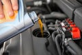 Mechanic pouring oil into car engine Royalty Free Stock Photo
