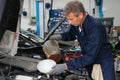 Mechanic Pouring Oil In Car Engine Royalty Free Stock Photo