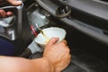 mechanic pouring oil to vehicle engine. serviceman changing motor oil in automobile repair service. maintenance & checkup in car Royalty Free Stock Photo