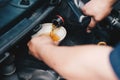 Mechanic pouring oil to vehicle engine. serviceman changing motor oil in automobile repair service. maintenance & checkup in car Royalty Free Stock Photo