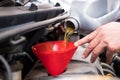 mechanic pouring oil to vehicle engine. serviceman changing motor oil in automobile repair service. maintenance & checkup in car