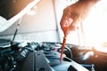 The mechanic is pulling the dipstick in the engine compartment to check the oil level Royalty Free Stock Photo