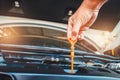 The mechanic is pulling the dipstick in the engine compartment to check the oil level Royalty Free Stock Photo