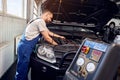 Mechanic pumps freon into the conditioning system on auto service Royalty Free Stock Photo