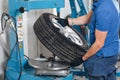 Mechanic removes car tire closeup. Machine for removing rubber from the wheel disc Royalty Free Stock Photo